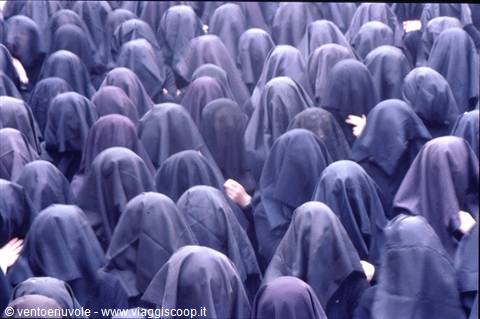 Crowd of women in blue veils, hands raised