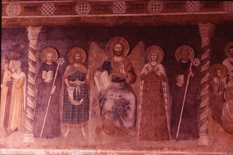 Medieval fresco of Christ enthroned with haloed saints holding books