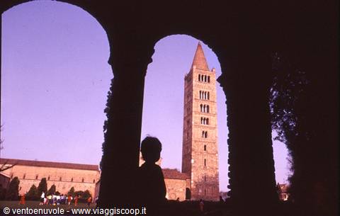 Child silhouetted between cloister arches, Romanesque bell tower of Pomposa