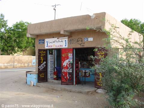Small mud-brick shop with Coca-Cola signs along a dusty rural road