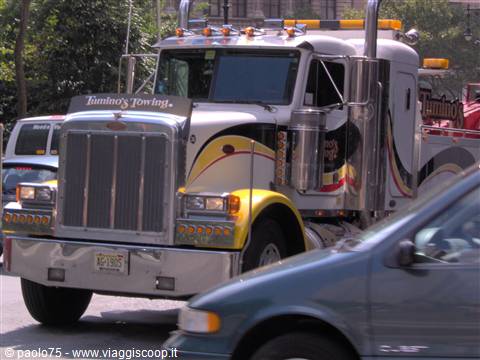 White and yellow Lumino's Towing tow truck driving on city street