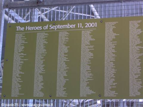 Memorial plaque "The Heroes of September 11, 2001" listing names, mounted on a metal fence
