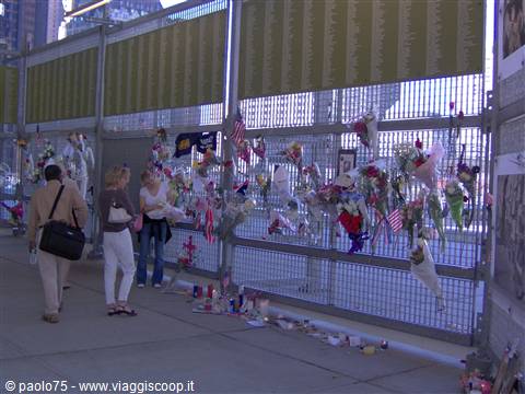 Flowers and flags hanging on the Ground Zero memorial fence, New York