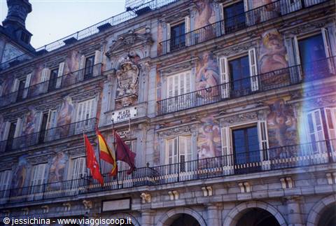 Frescoed facade of Madrid's Plaza Mayor with Spanish flags waving