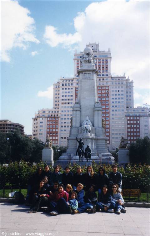 Group of tourists sitting in front of the Cervantes monument in Madrid