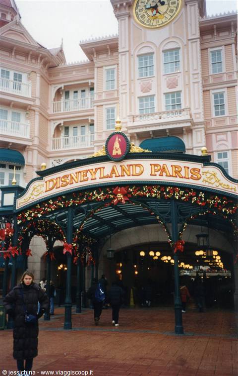 Entrance archway decorated with red flowers at Disneyland Paris, pink hotel