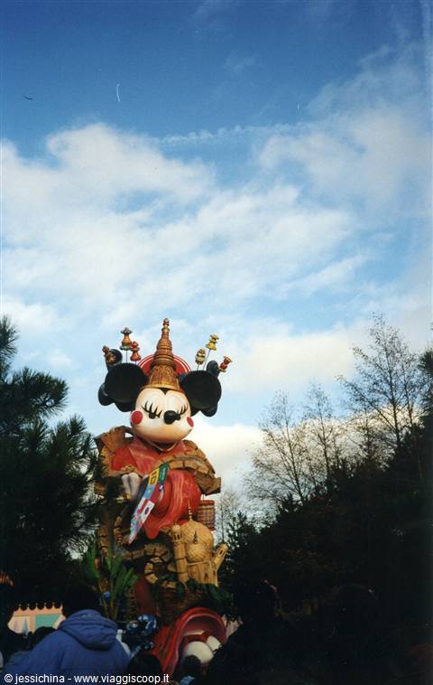 Minnie Mouse parade float in red costume at Disneyland under cloudy sky
