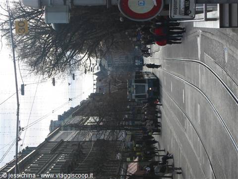 Tram on tracks among pedestrians and historic buildings, road signs, winter light