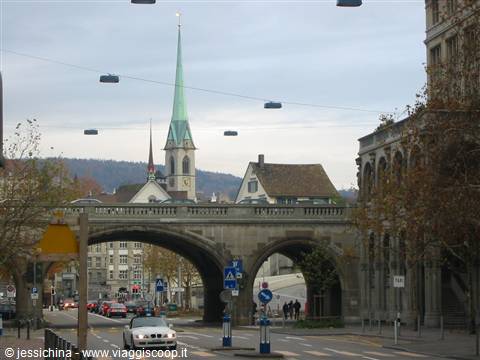 Stone bridge with the green spire of Fraumünster church in Zurich