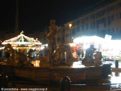Bronze Neptune fountain at night in Bologna with lit market stalls