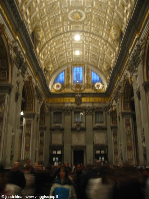 Inside St. Peter's Basilica: gilded coffered ceiling and visitors in the nave