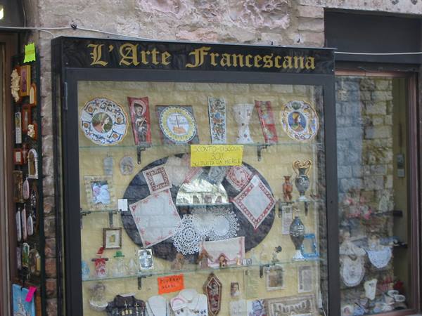 Shop window with painted ceramics and lace souvenirs, L'Arte Francescana sign, Assisi