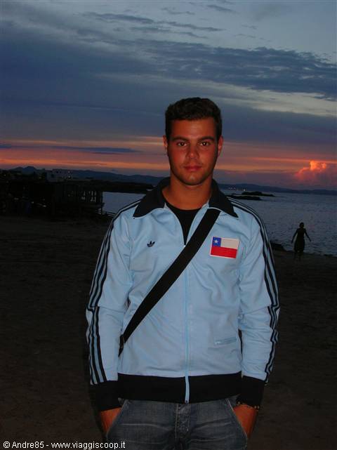 Young man in light blue Adidas jacket on the beach at dusk