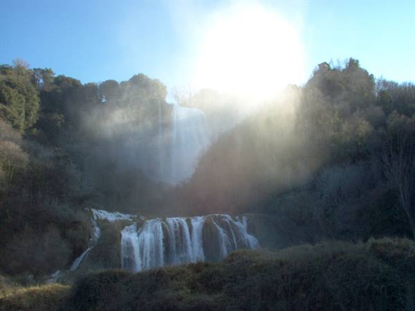 Marmore Falls, foaming water drops between trees and sunlit mist