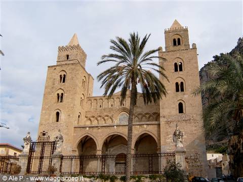 Cefalù Cathedral with twin Norman towers, palm tree and statues by the entrance
