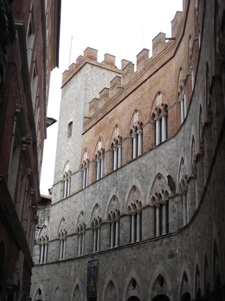 Curved brick facade with Gothic mullioned windows, Palazzo Sansedoni in Siena
