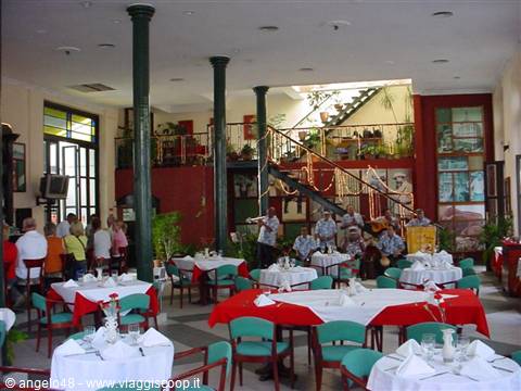 Restaurant hall with green columns, set tables and musicians playing