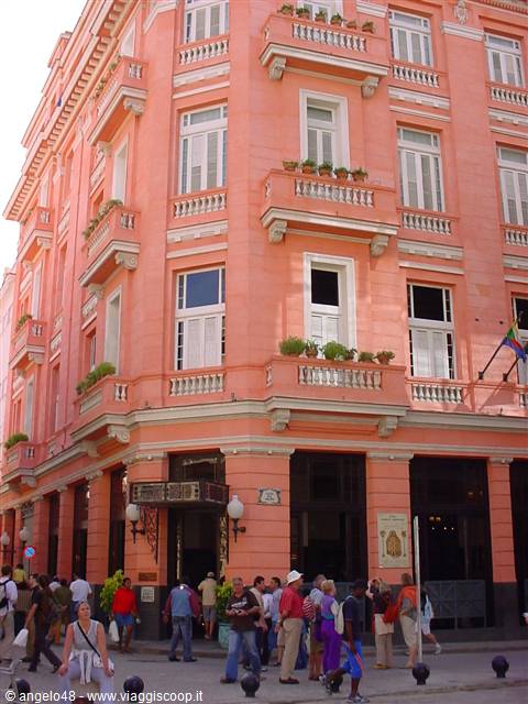 Tourists outside the Hotel Ambos Mundi, pink corner building