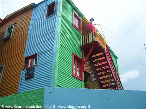 Man in red on balcony of colorful sheet-metal house, Caminito, Buenos Aires