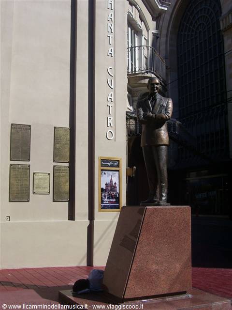 Bronze statue of Carlos Gardel in front of the theater, commemorative plaques on wall