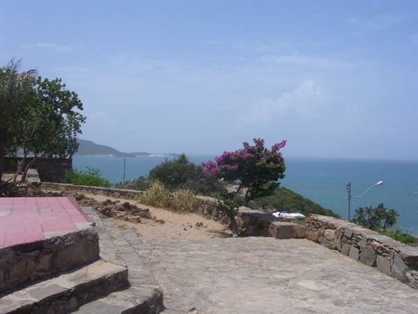 Stone terrace with blooming bougainvillea above the blue bay