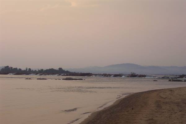 Sand along the wide Mekong, rapids among islands in the haze