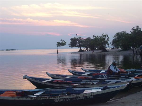 Wooden fishing boat 'Garota do Amor', fisherman nearby, pink dawn over the shore