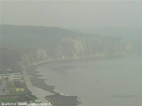 white cliff and beach in fog, seafront promenade and buildings on the left