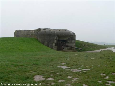German gun bunker built into the grassy hill, grey sky