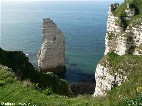 Étretat's Aiguille: white limestone sea stack between grassy cliffs and ocean