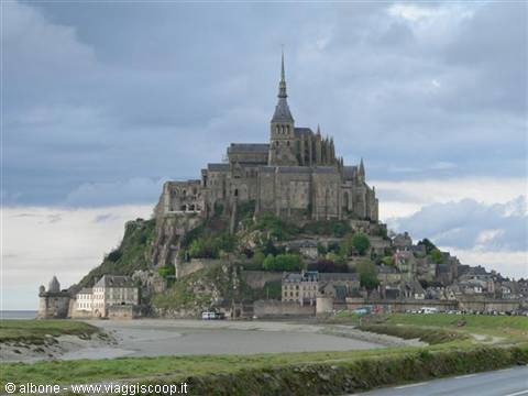Mont Saint-Michel: the medieval stone abbey rises above the bay under cloudy skies