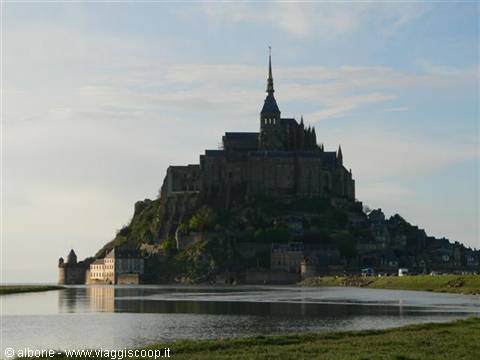 Mont Saint-Michel, stone abbey reflected in the water under morning light