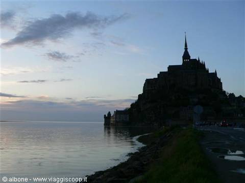 Mont Saint-Michel silhouetted at dawn, reflected in the bay's water