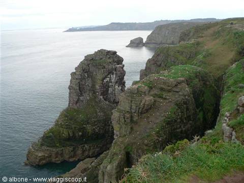 Granite cliffs with green grass above the grey sea at Pointe de Pen-Hir