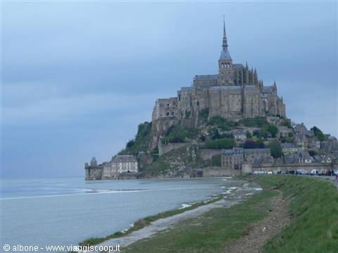 Mont Saint-Michel abbey on the rock, grey sky over the tidal bay