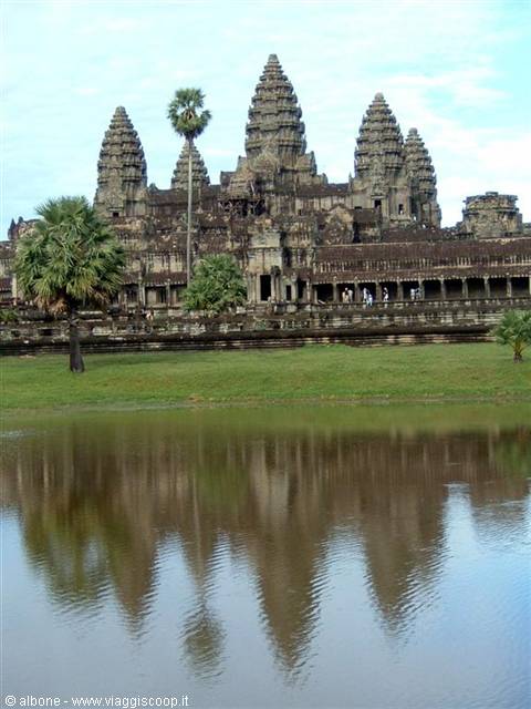 Angkor Wat stone towers reflected in the pond in front of the temple