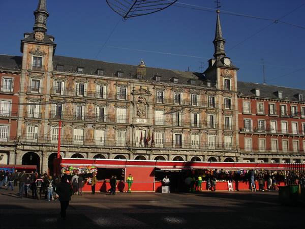 Plaza Mayor, Madrid: red Christmas market stalls beneath the Casa de la Panadería