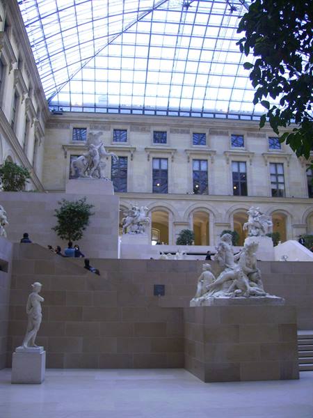 Louvre courtyard with glass roof and marble sculptures