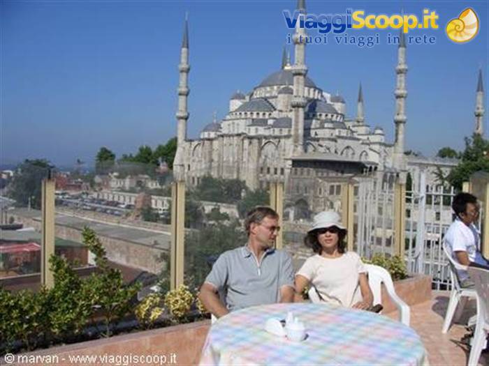 Couple seated at a rooftop café table in front of the Blue Mosque