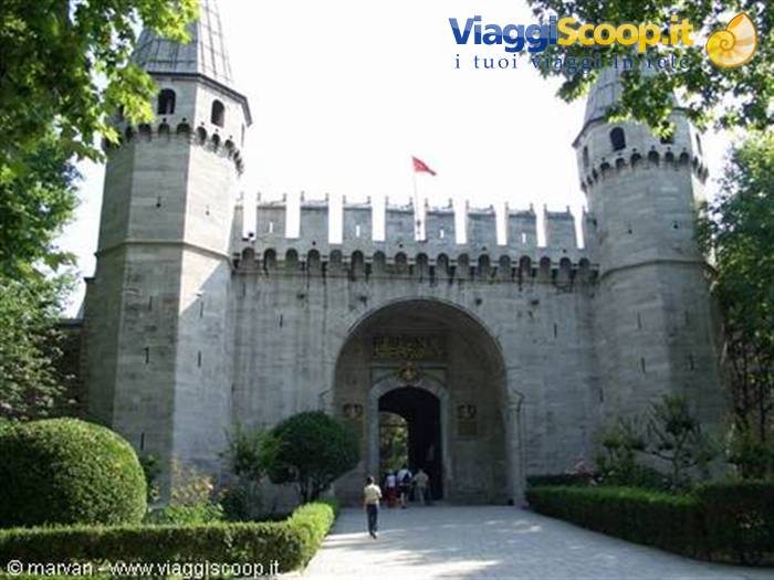 Gate of Salutations at Topkapi Palace, stone towers with Turkish flag, visitors beneath the arch