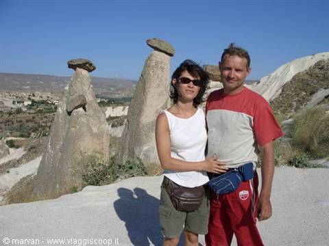 Couple posing beside Cappadocia fairy chimneys