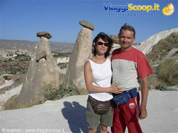 Couple posing beside Cappadocia fairy chimneys