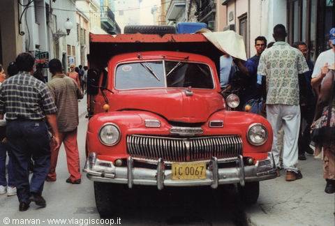Vintage red truck on a crowded narrow street in Havana