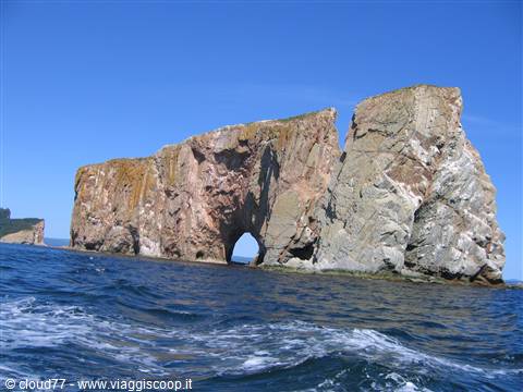 Percé Rock, limestone sea stack with natural arch, choppy water and blue sky