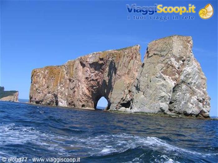 Percé Rock, limestone sea stack with natural arch, choppy water and blue sky
