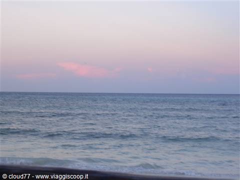 Blue sea with small waves under a pink twilight sky