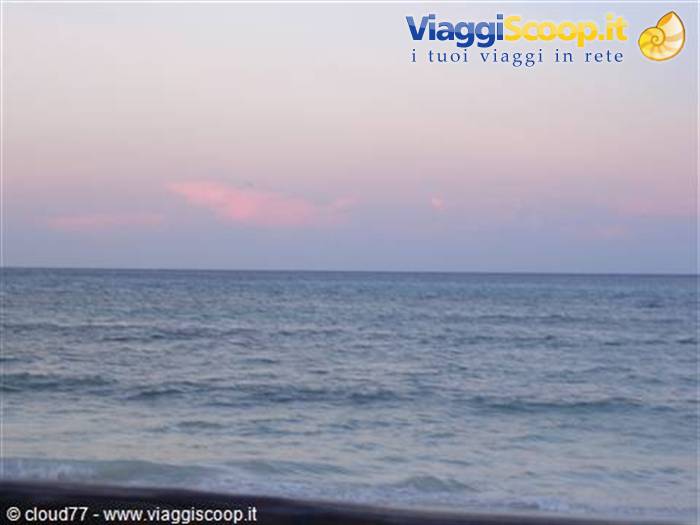 Blue sea with small waves under a pink twilight sky