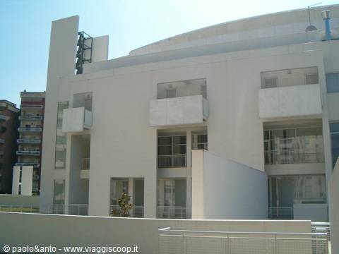 White modern concrete building with protruding balconies in bright light