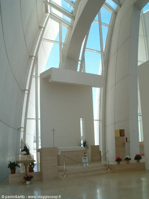 White interior of the Jubilee Church, travertine altar beneath glass sails