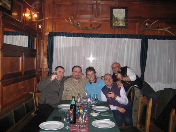 Four friends toast with wine in a wooden tavern decorated with antlers